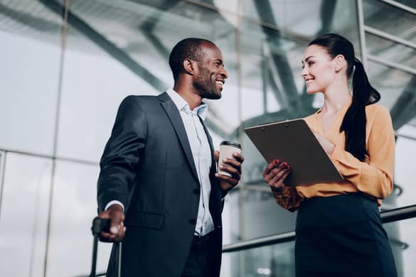 two colleagues smiling and chatting at work