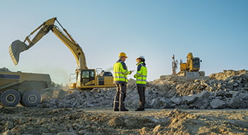 construction works stand on a worksite with equipment in the background